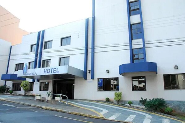 A hotel with a modern facade, a sign indicating it is a hotel, and a clear entrance. - Hotel Riviera (São José do Rio Preto)