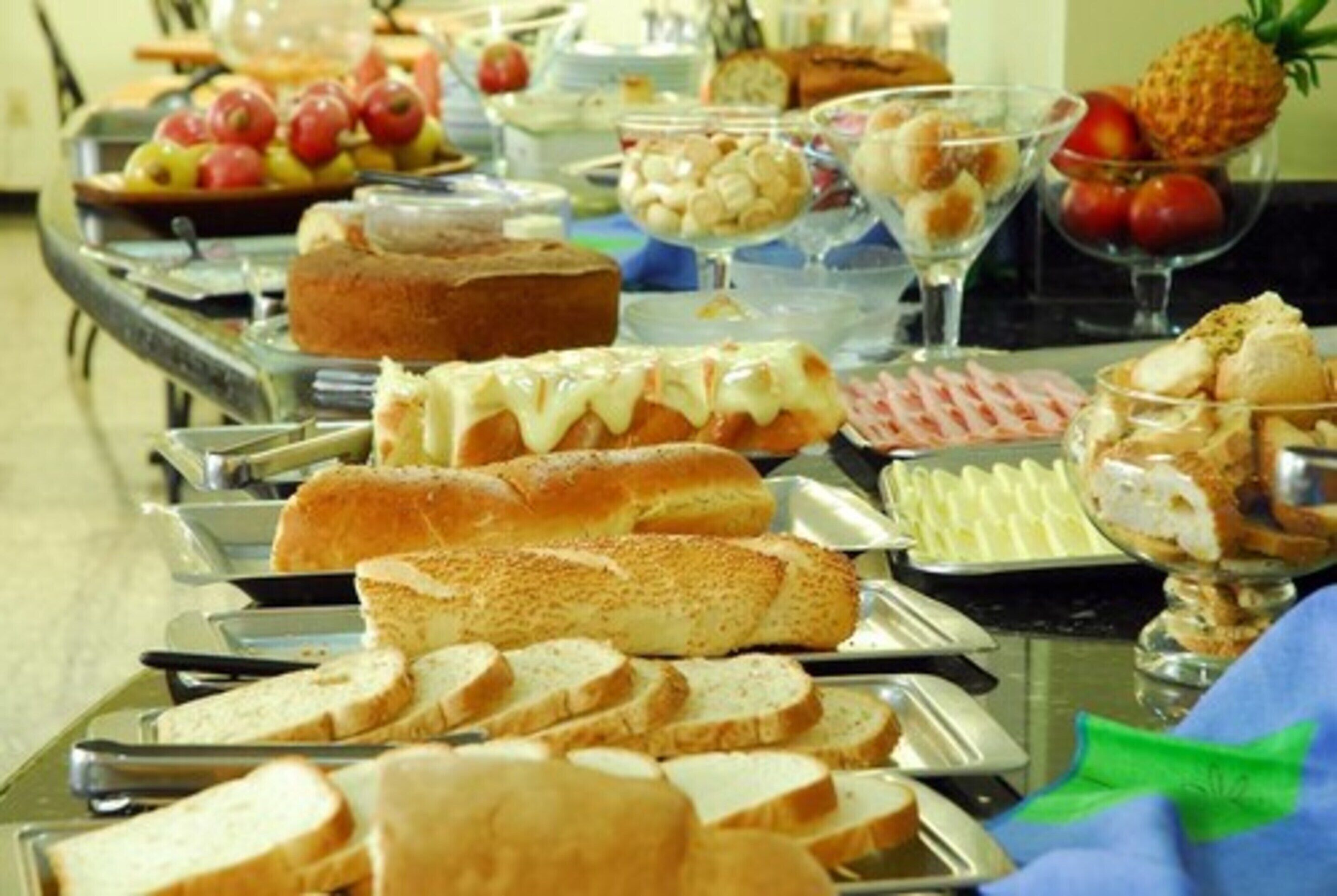 Ein reichhaltiges Buffet mit verschiedenen Speisen, darunter Brot, Gebäck und Obst.