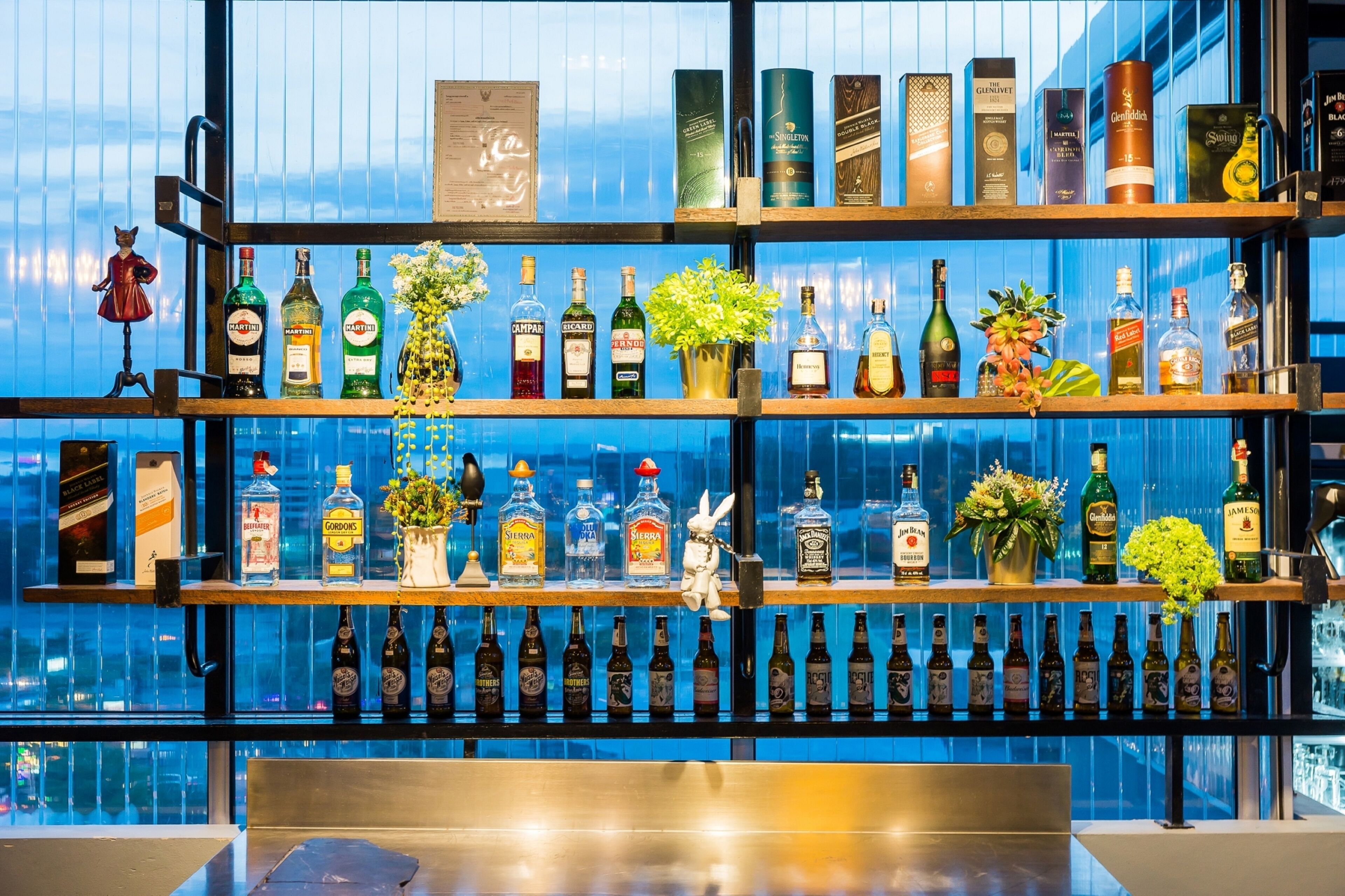 A bar with multiple shelves of liquor bottles and decorative items.