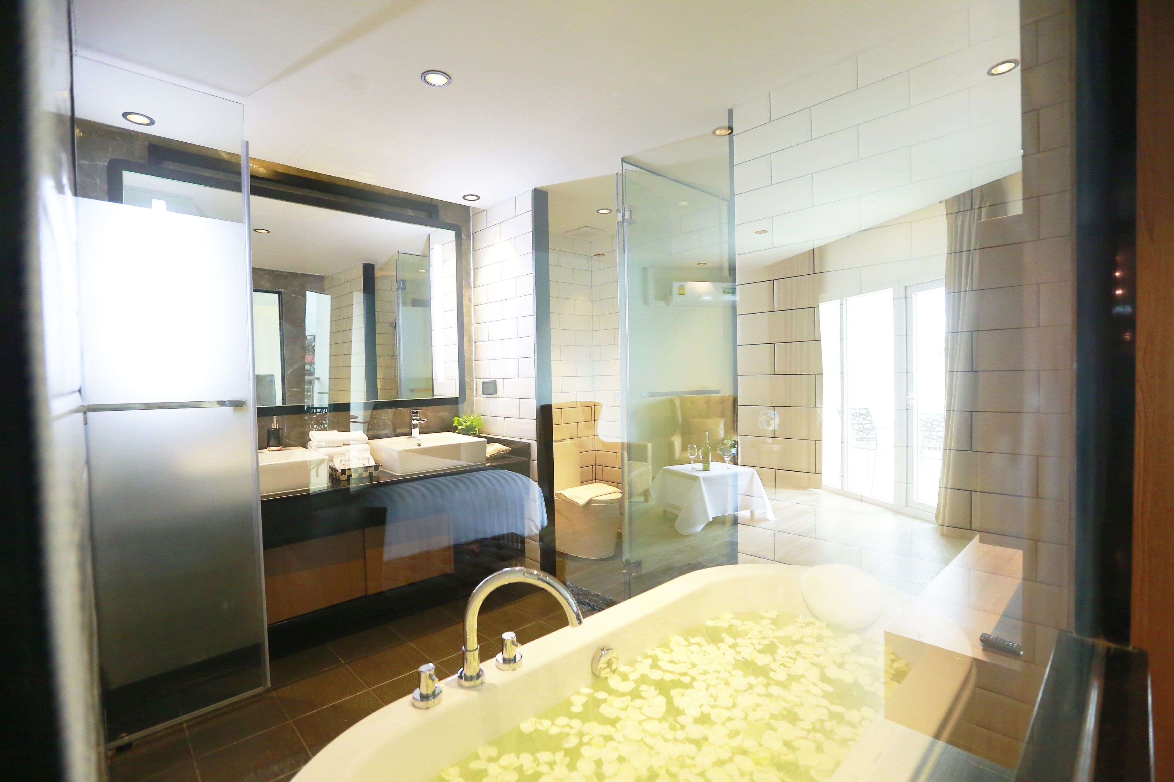A modern bathroom with a large bathtub, a glass-enclosed shower, and a vanity with a mirror.