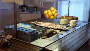Un espace buffet proposant une variété d’aliments, notamment des fromages, des fruits et des produits emballés.