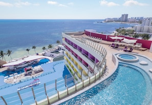 Ein Hotel mit Pool, Liegestühlen und Meerblick.