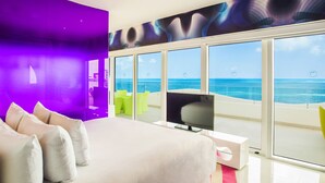 A modern hotel room with a large bed, a flat-screen TV, and a balcony with a sea view. - Temptation at The Tower Cancún All Inclusive - Adults Only (Cancun)