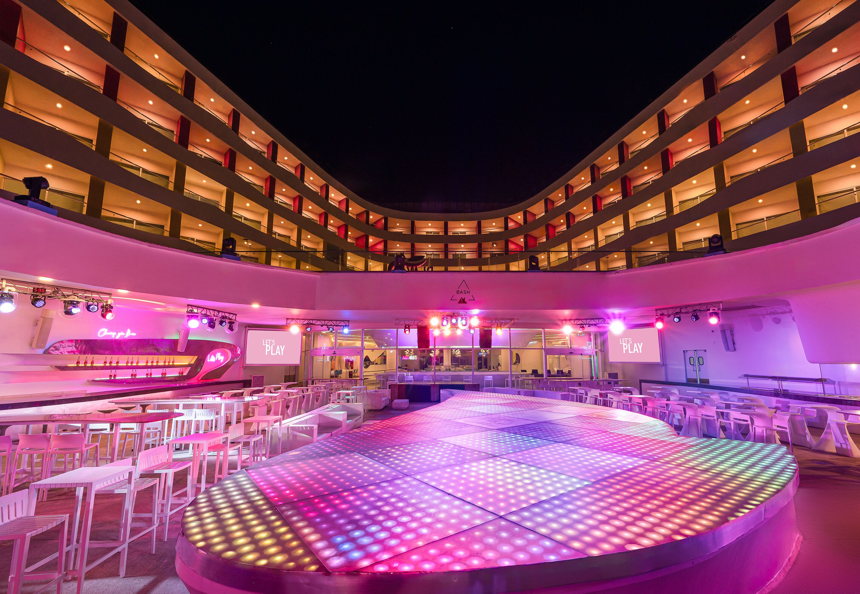 A spacious indoor venue with a central stage, multiple balconies, and a modern architectural design.