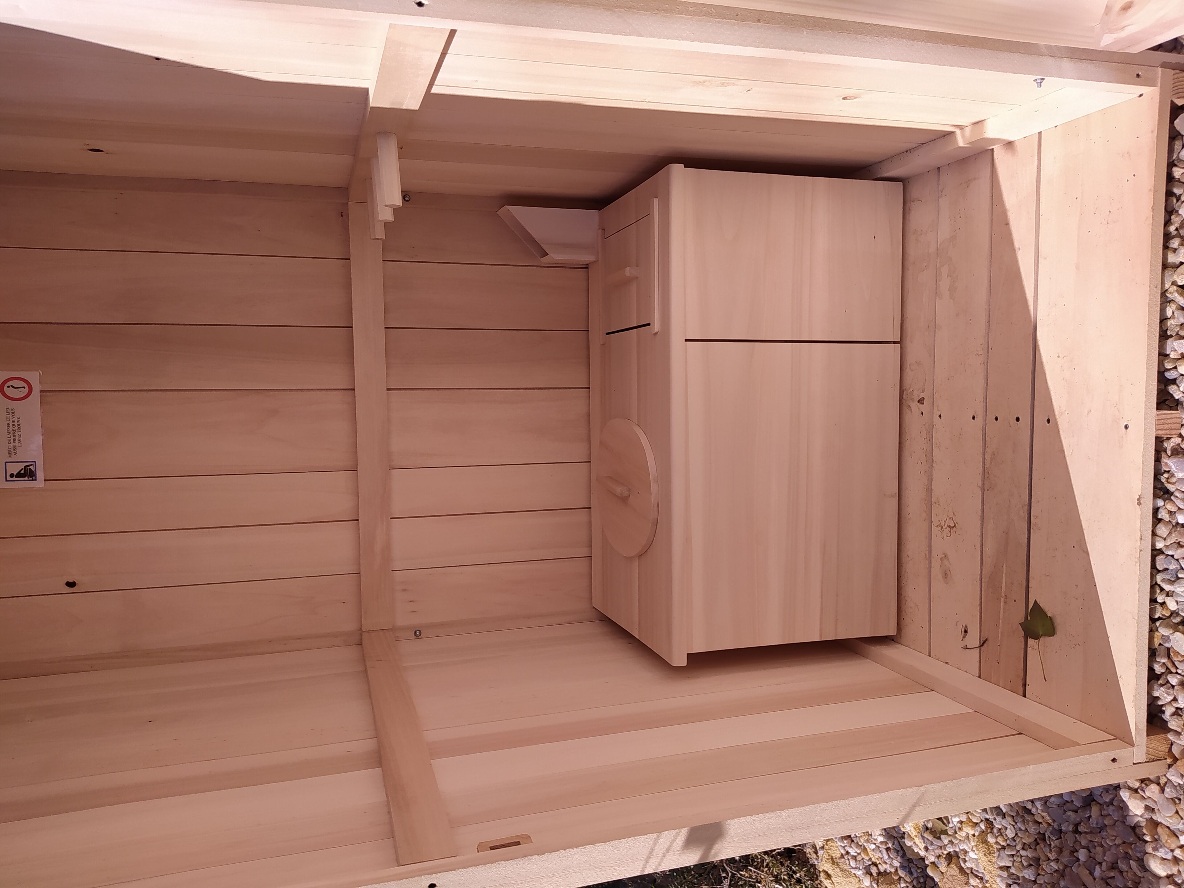 Un interior de madera con un armario empotrado y una pequeña rejilla de ventilación.