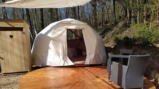 A round wooden table with a white tent and wicker chairs in a forest setting. - La Maison de Tari (Vitrac)
