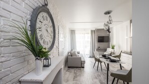 A modern kitchen with a dining area, a large clock, and a plant. - Good Time Apartment (Warsaw)