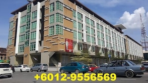 A multi-story building with a modern architectural design, featuring a mix of glass and concrete facades.