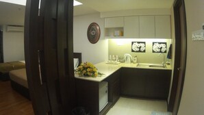 A compact kitchen with a sink, countertop, and a small trash bin.