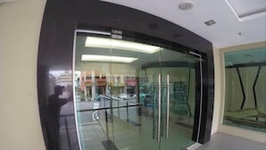 A modern building entrance with a glass door and a metal railing.