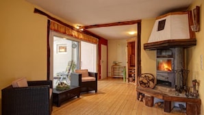 Una sala de estar acogedora con chimenea, mobiliario de mimbre y suelo de madera.