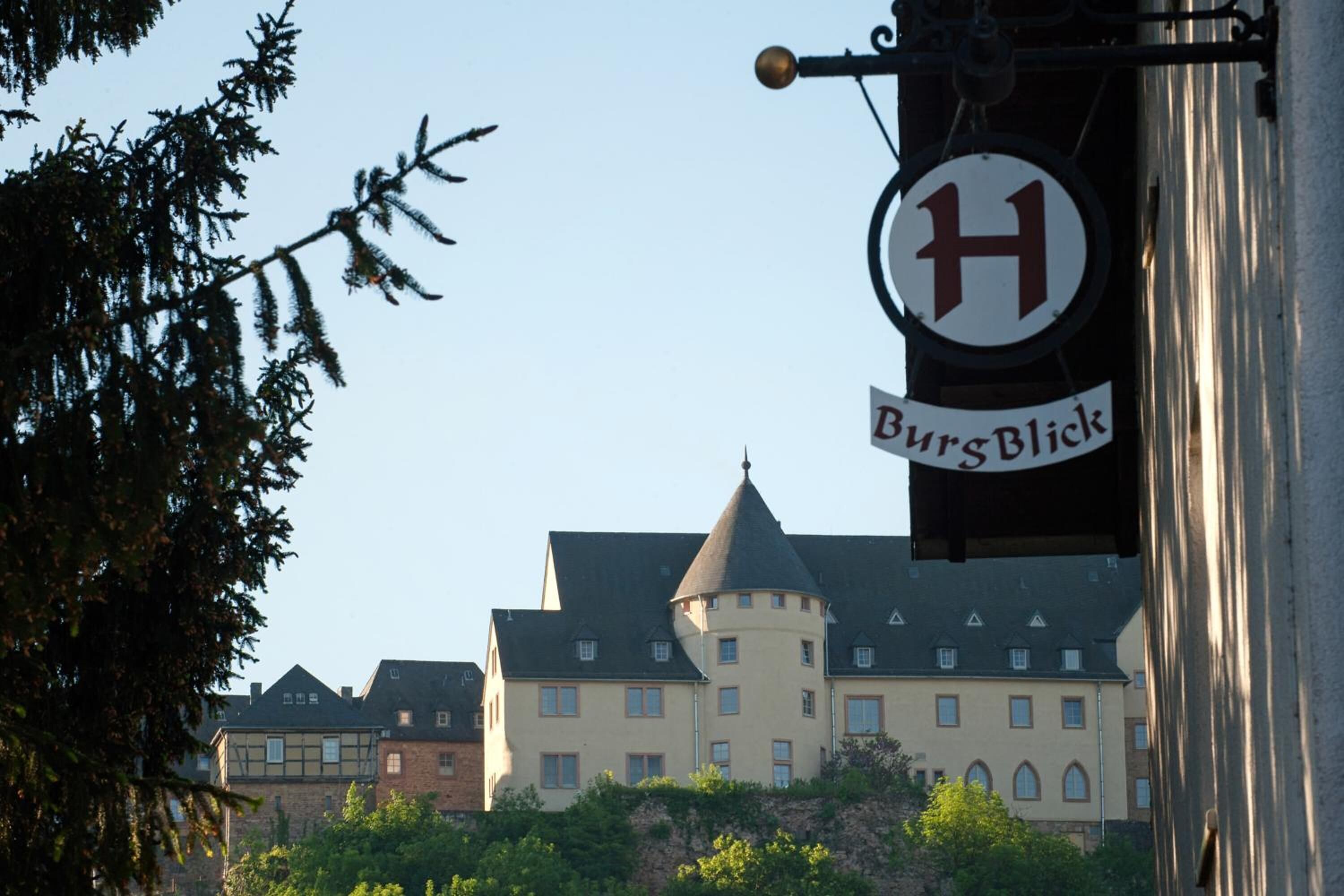 En skylt med bokstaven ’H’ och ordet ’Burgblick’ som visar att det är ett hotell.