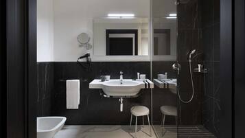 A modern bathroom with a large sink, mirror, and shower.