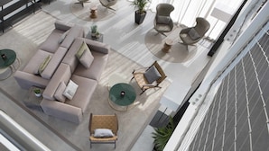 Un espace de détente moderne comprenant un canapé d’angle, des fauteuils et une petite table.