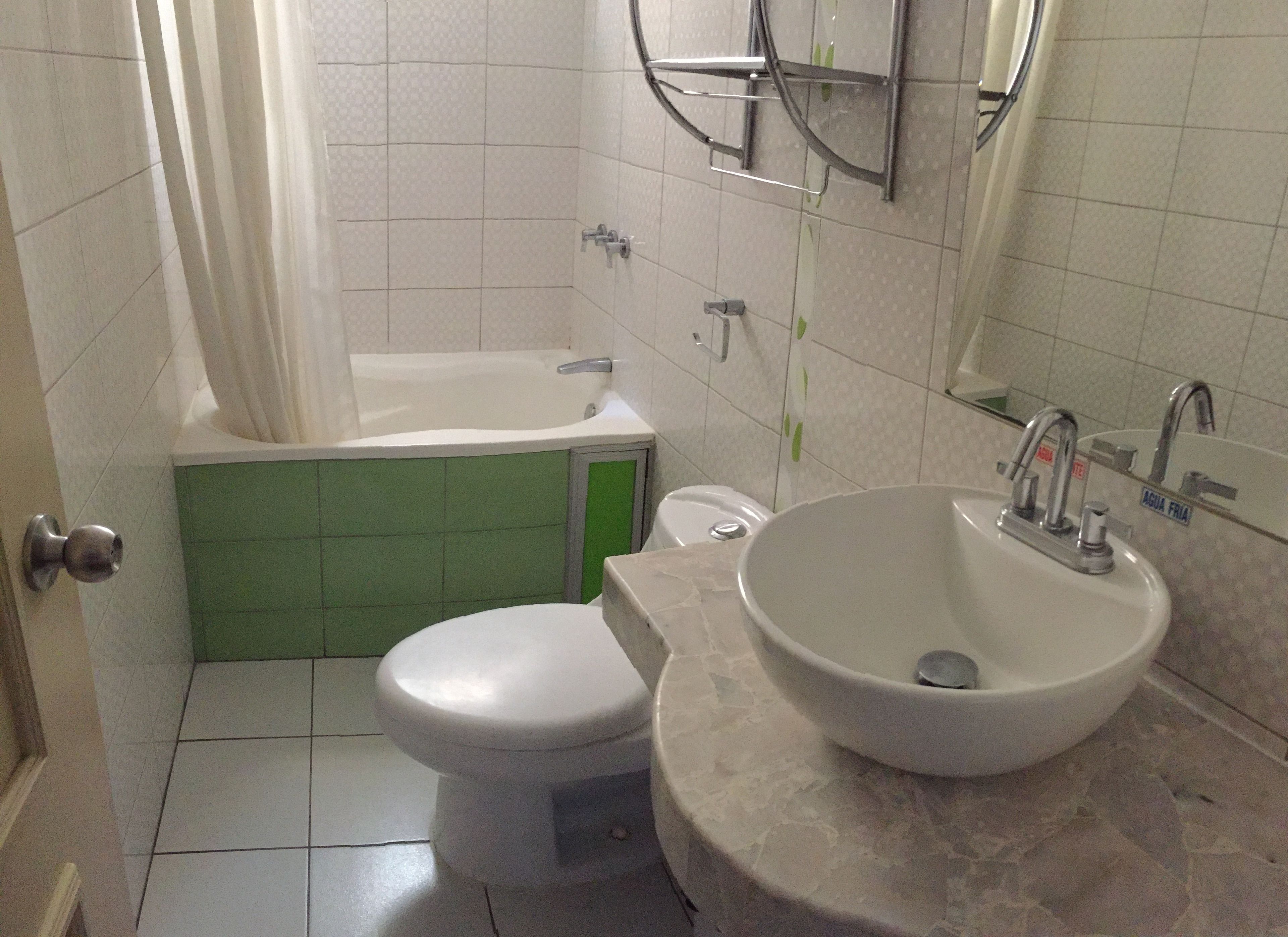 A bathroom with a toilet, a bathtub, and a sink.