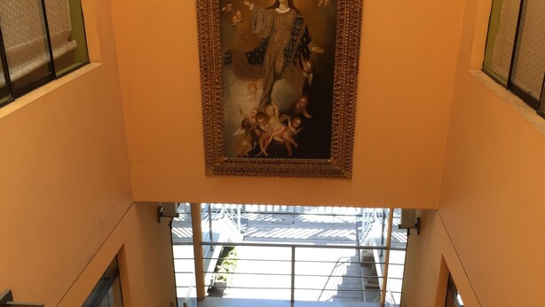 A corridor with a framed painting on the wall, glass doors, and trash bins. - Apart Hotel Incamin (Arequipa)