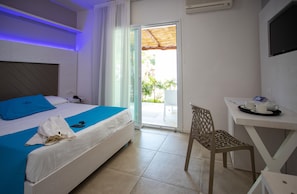 A hotel room with a bed, a desk, a chair, and a view of the outdoors. - BV Kalafiorita Resort (Zambrone)