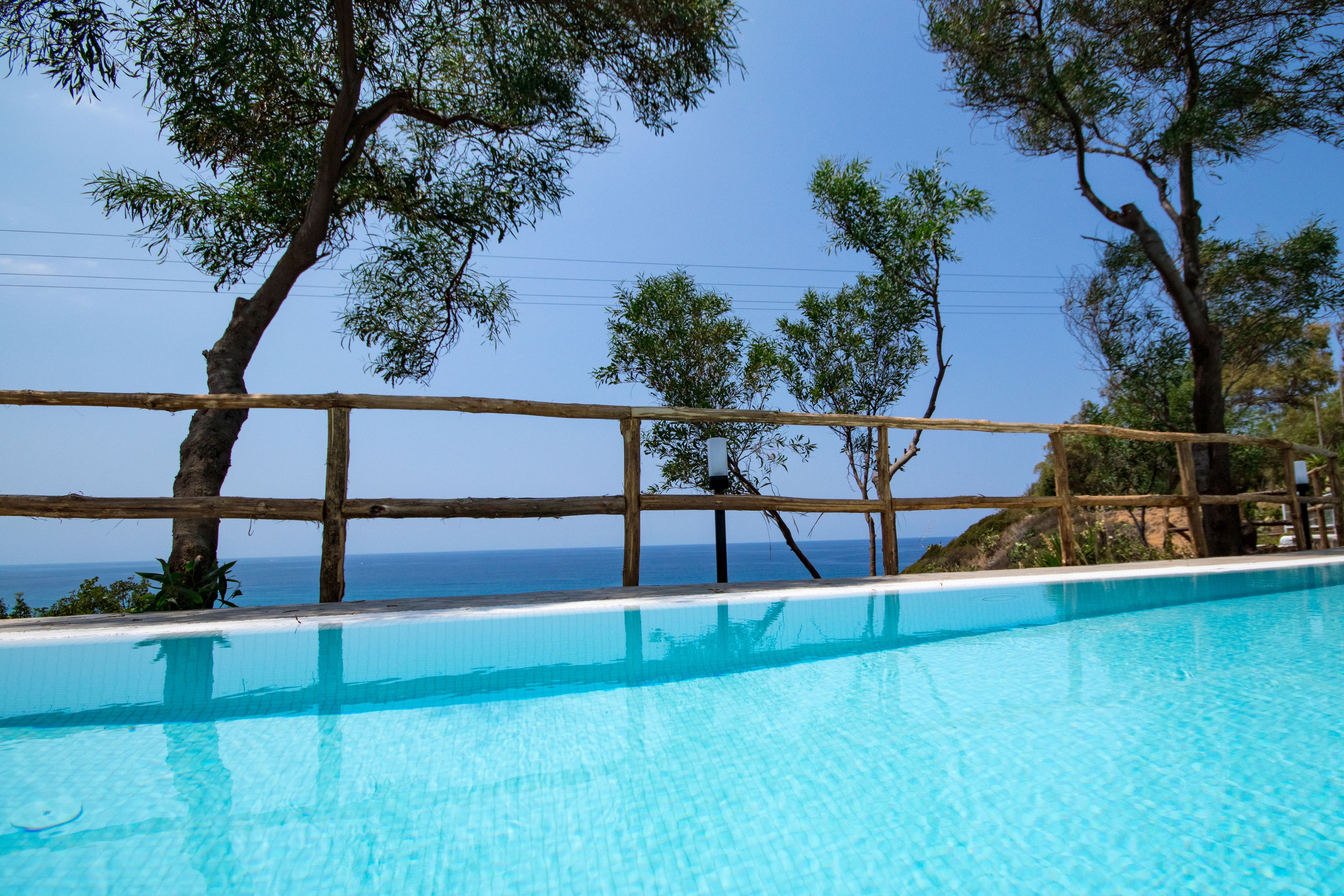 outdoor pool, an infinity pool, pool umbrellas, pool loungers