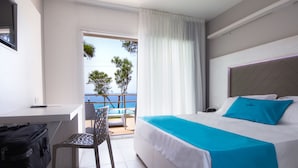 A hotel room with a bed, a desk, and a chair. There is a view of the sea through the window. - BV Kalafiorita Resort (Zambrone)