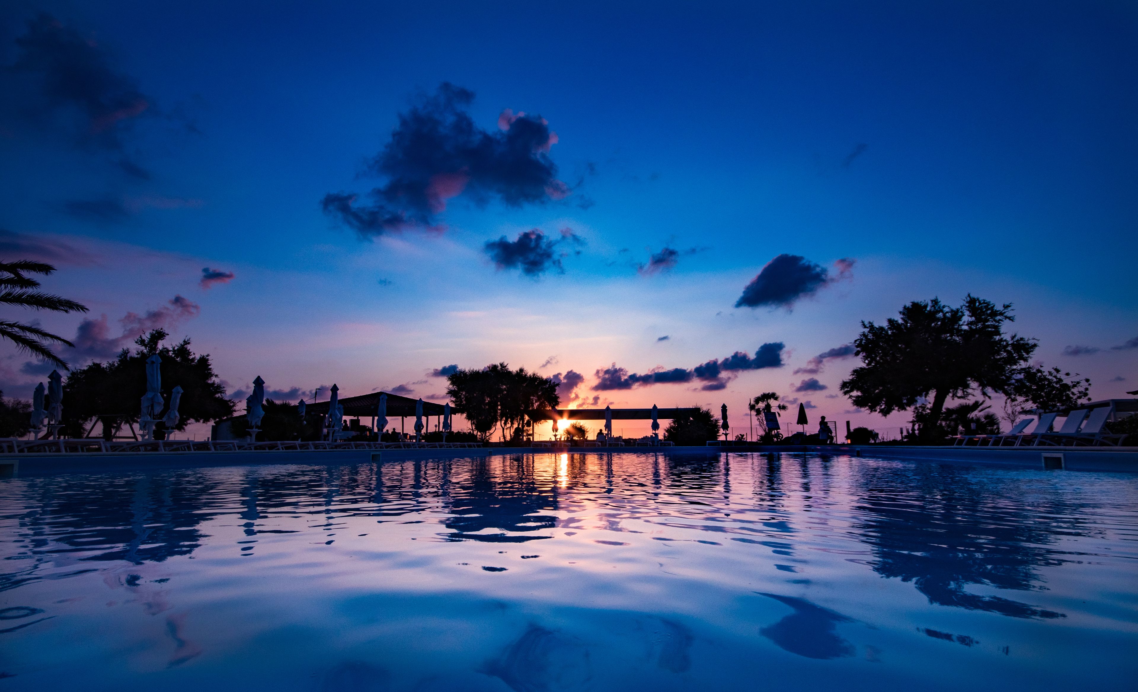 Outdoor pool, an infinity pool, pool umbrellas, pool loungers