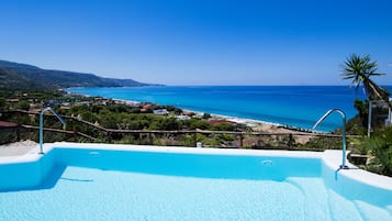 Een buitenzwembad, een infinity pool, parasols voor strand/zwembad