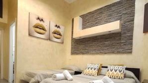A bedroom with a large bed, two pillows, and a wall-mounted shelf. - Double B Ferruccio I (Rome)