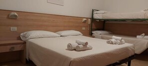 A hotel room with a wooden headboard, a single bed, a nightstand, and a bunk bed. - Hotel Brezza (Rimini)