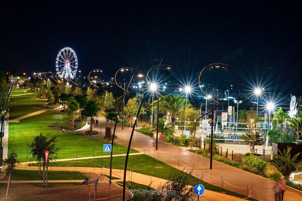 A nighttime view of a well-lit park with a Ferris wheel, pathways, and street lamps. - Hotel Brezza (Rimini)