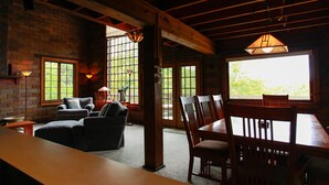 A cozy room with a fireplace, a sofa, and a dining table with chairs. - River's Bend (Saugatuck)