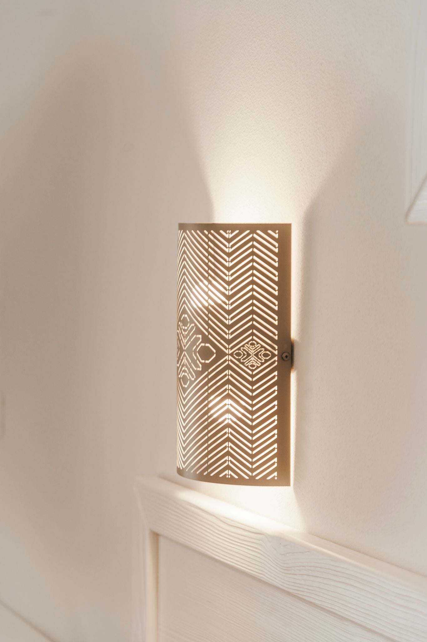 A wall-mounted light fixture with a geometric pattern.