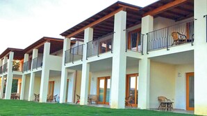 A row of modern hotel buildings with multiple balconies, each with a wooden ceiling and white walls. - Stella Marina Camere sul mare (Budoni)