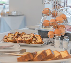 A buffet table with sliced bread and eggs. - Stella Marina Camere sul mare (Budoni)