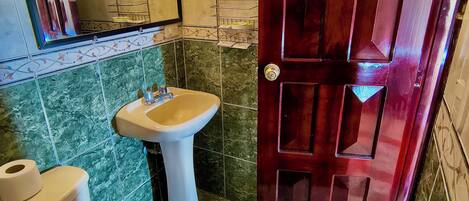 A bathroom with a toilet, sink, and mirror.
