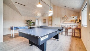 A room with a ping pong table, wooden flooring, and a bar area with chairs. - Stunning home in Vejby with sauna (Vejby)