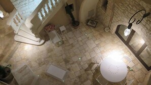 A stone-floored interior with a staircase, a round table, and a stone oven. - Dimora dell'Osanna (Carovigno)