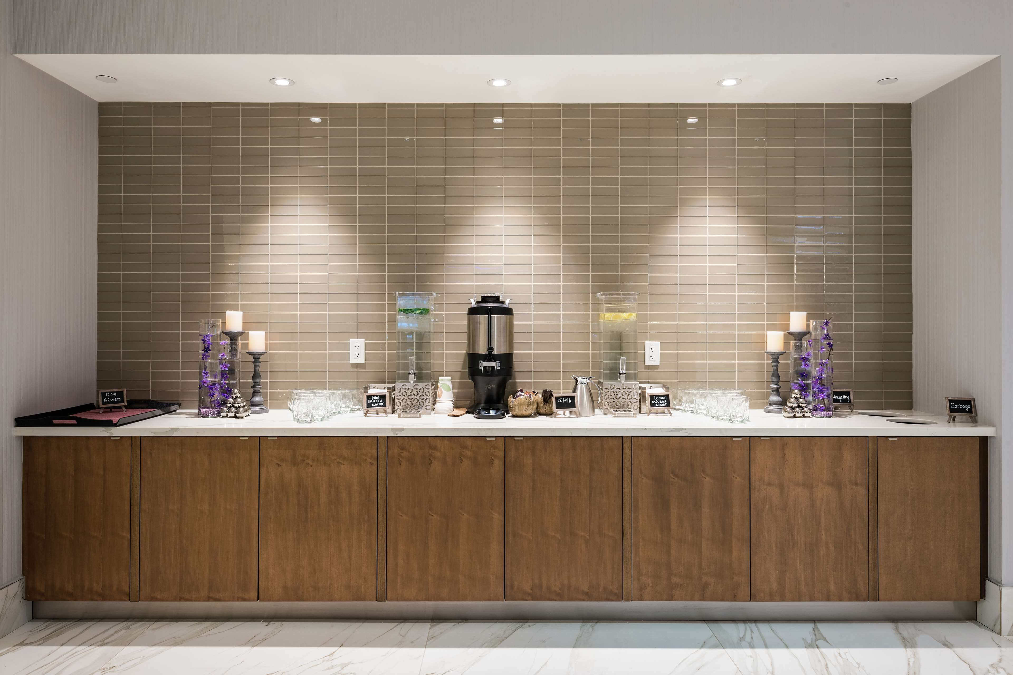 A modern bathroom with a large counter, two sinks, and a coffee machine.