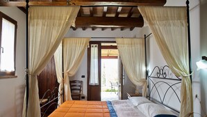A bedroom with a four-poster bed, curtains, and a wooden ceiling. - Sant'Apollinare (Piancastagnaio)