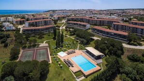 Un ensemble résidentiel comprenant plusieurs immeubles d’appartements, un court de tennis et une piscine.