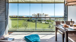 Un balcon offrant une vue dégagée sur un immeuble et un paysage verdoyant.