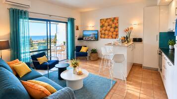 A modern living room with a sofa, coffee table, and a view of the sea.