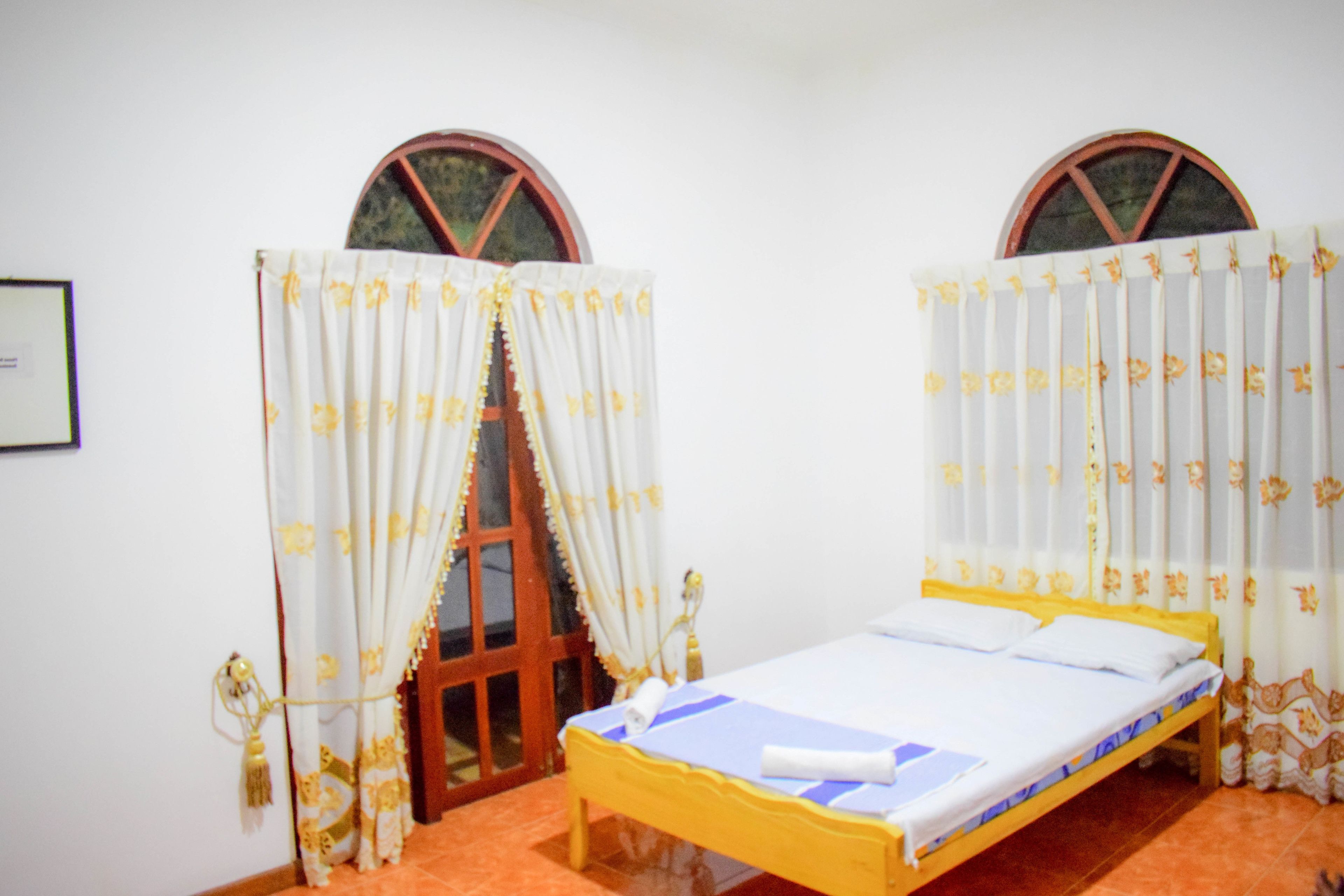 A room with a bed, curtains, and a window.