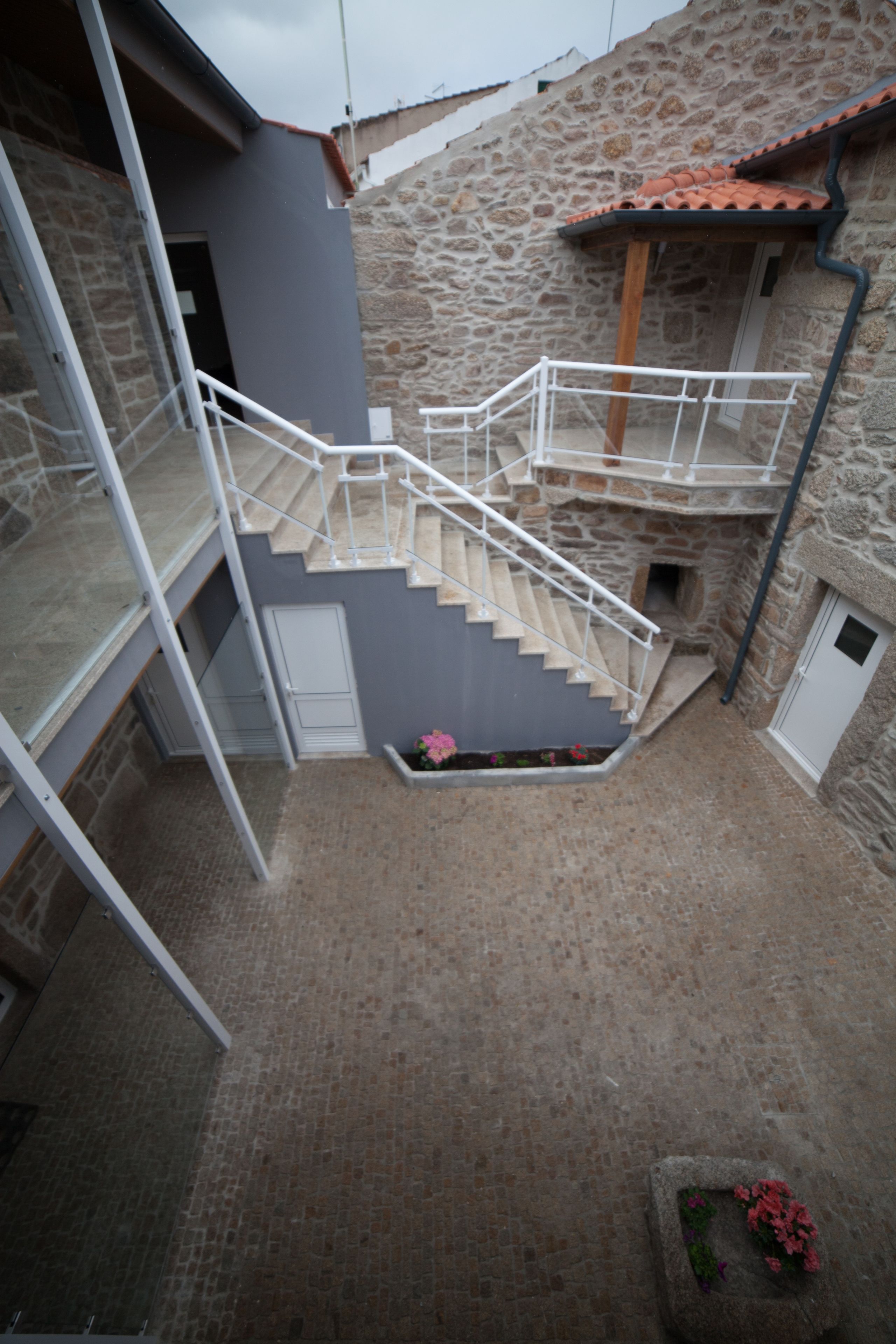A stone building with a staircase leading to a second floor.