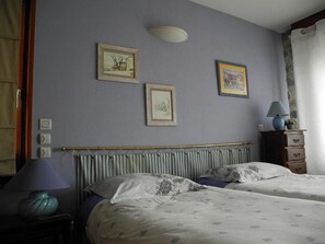 A bedroom with two beds, a dresser, a lamp, and framed pictures on the wall. - Chambres d'hôtes du Plateau de la Danse (Saint-Etienne)