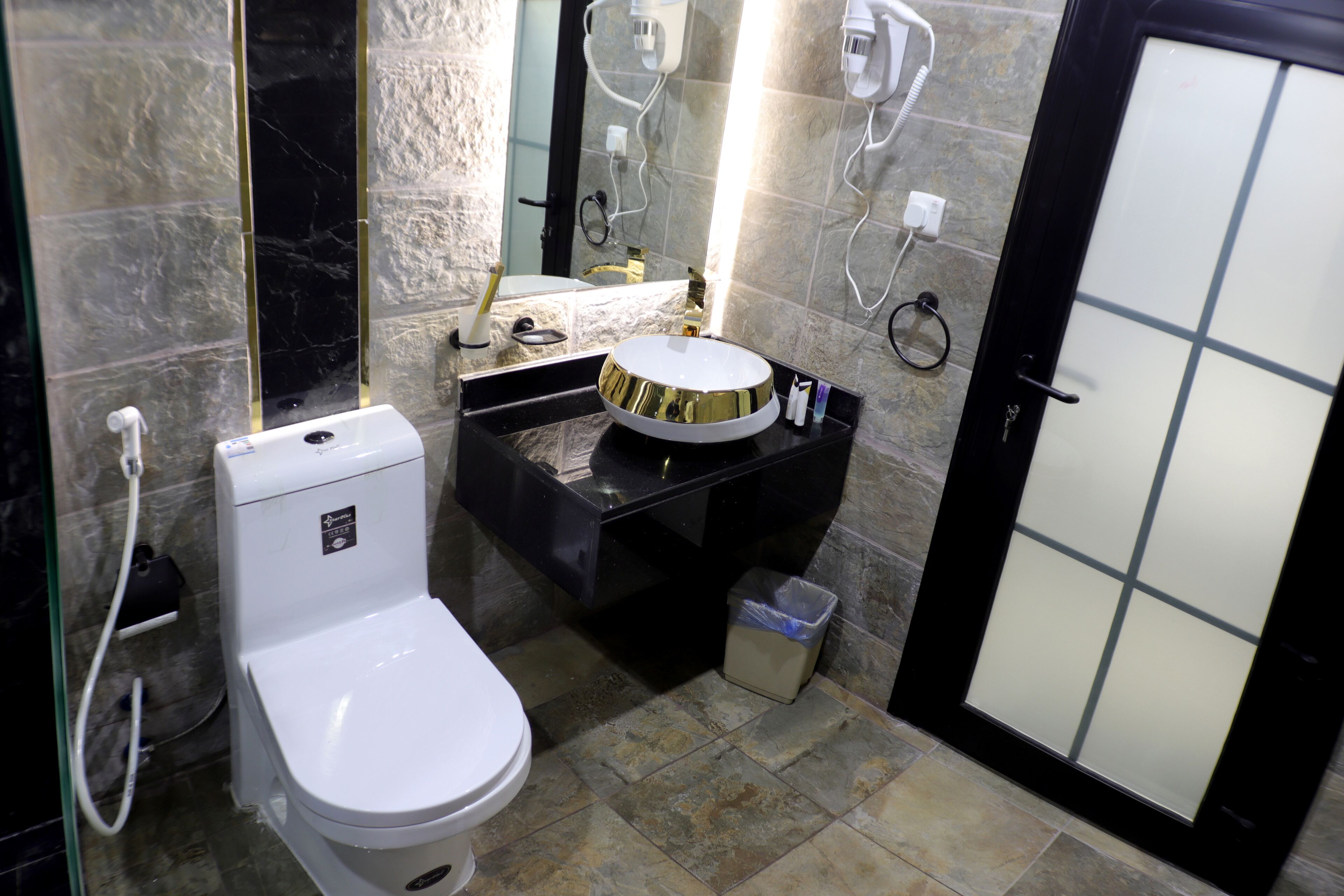 Une salle de bain avec des toilettes, un lavabo et un miroir.