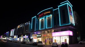 A building with illuminated signage, including a prominent sign with Arabic script. - Maskan Al Dyafah Serviced Apartments 2 (Dammam)