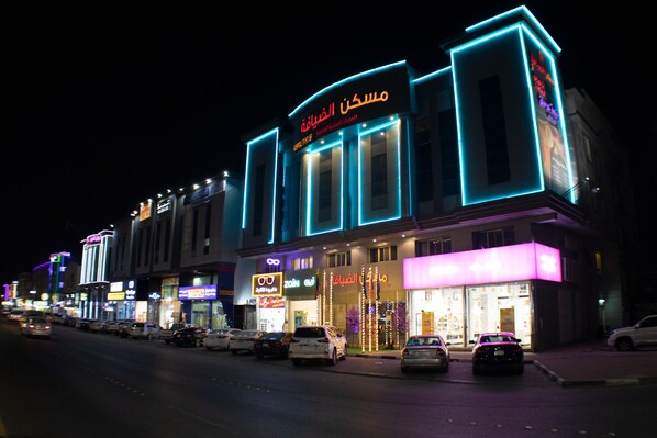 Een gebouw met verlichte reclameborden, waaronder een opvallend bord met Arabische letters.
