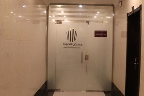 Um elevador moderno com um logotipo e texto em árabe, indicando a entrada de um hotel.