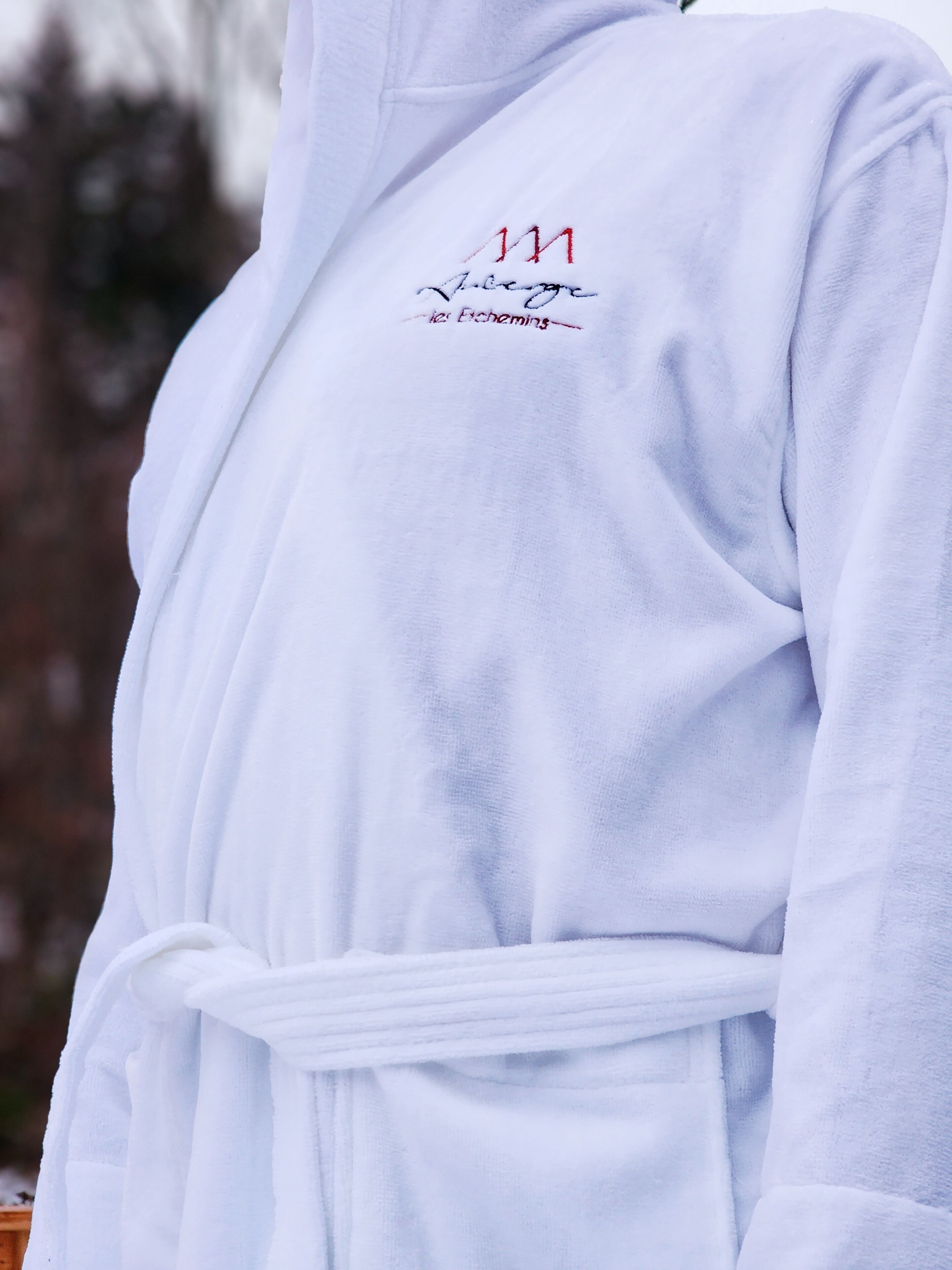 A white robe with embroidered text on the chest.