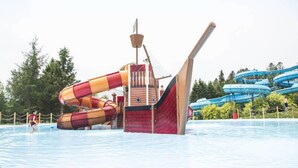 A water park with a pirate ship play area and a blue water slide. - Auberge Les Etchemins (Lac-Etchemin)