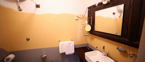 Un baño con inodoro, bidé, lavabo y espejo.